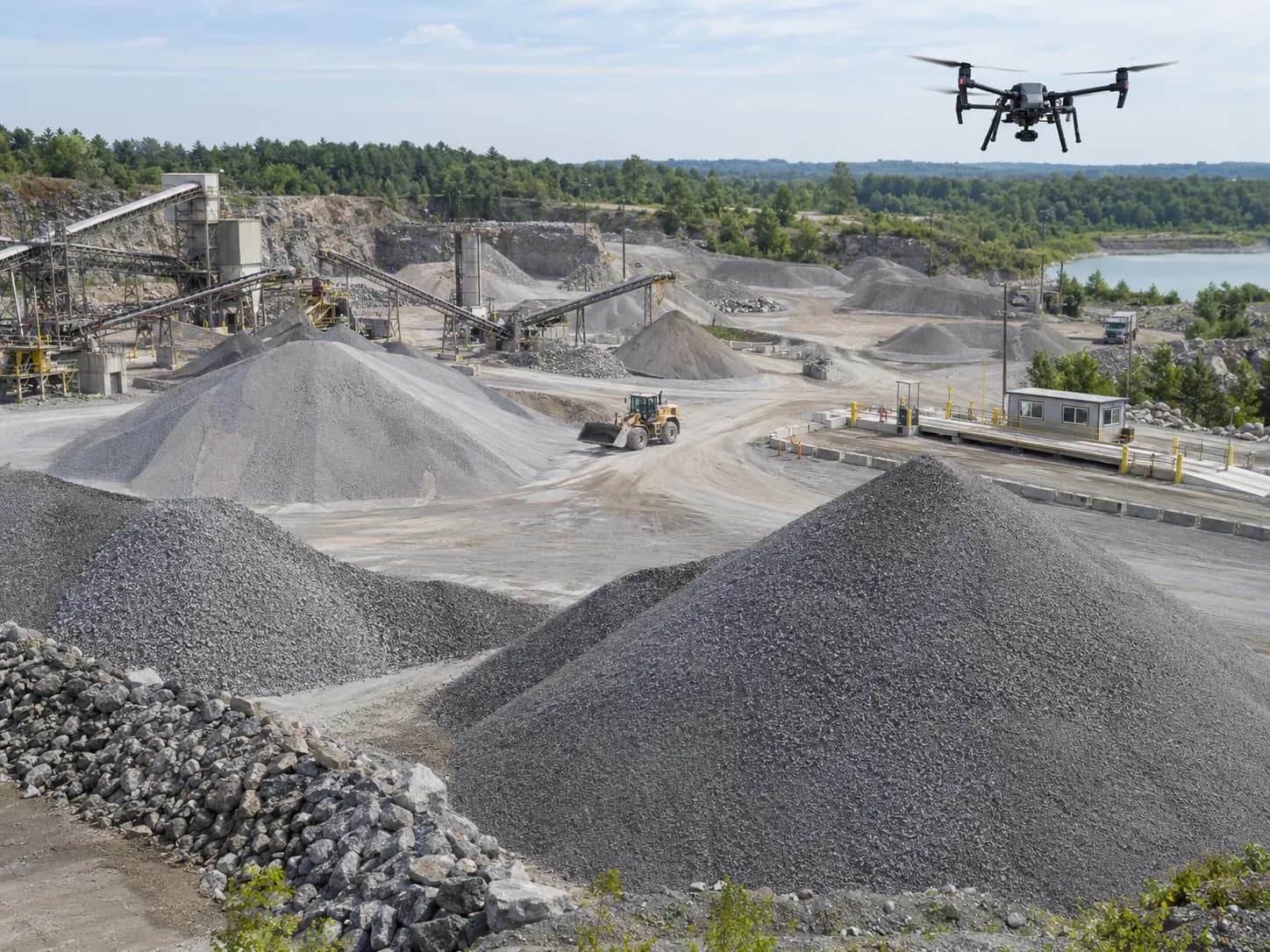 Aggregate site with multiple stockpiles and a drone collecting site data